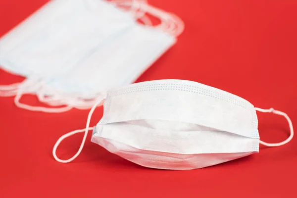 Selective focus of protective medical masks on red — Stock Photo