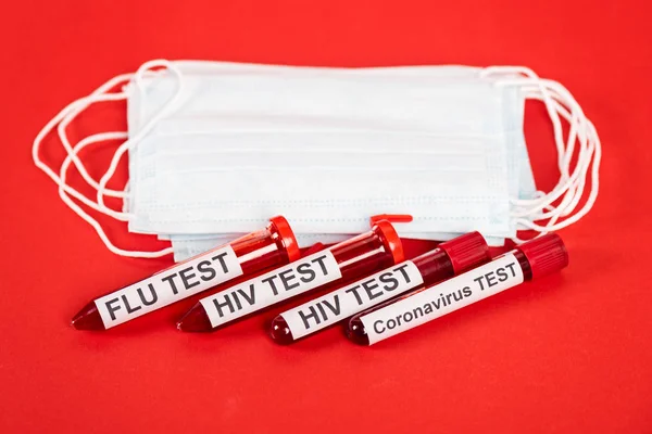 Samples with lettering near protective medical masks on red — Stock Photo