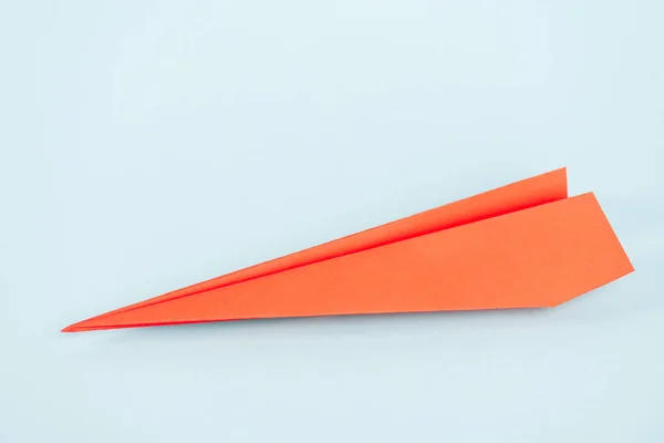 Avion en papier orange sur bleu avec espace de copie — Photo de stock