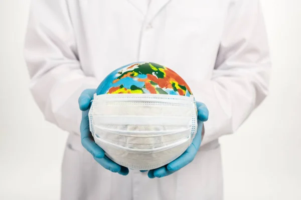 Recortado vista de científico celebración globo en máscara protectora aislado en blanco - foto de stock