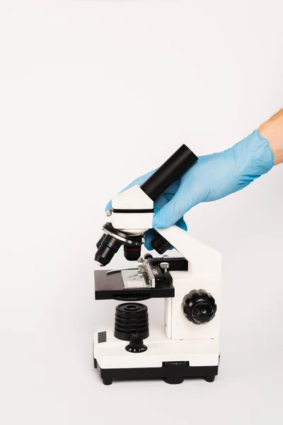 Vista recortada de científico tocando microscopio aislado en blanco - foto de stock