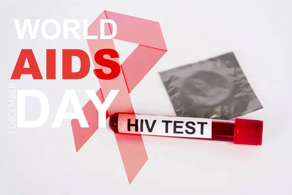 Sample with hiv test, condom in pack and world aids day lettering near red ribbon illustration on white — Stock Photo