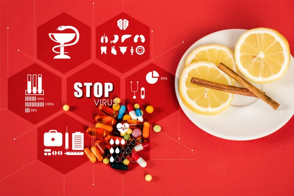 Вид сверху нарезанных лимонов и коричных палочек рядом с таблетками и прекратить вирусные надписи на красном — стоковое фото