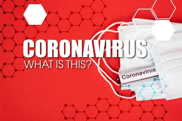 Вид зверху зразка з коронавірусом біля захисних медичних масок і коронавірусу що це за написи на червоному — стокове фото