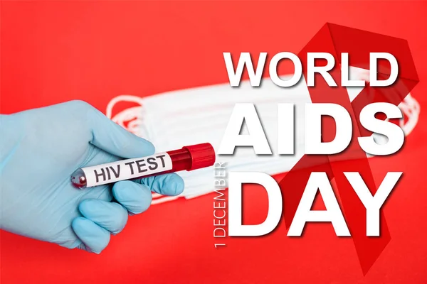 Cropped view of scientist holding sample with hiv test near medical masks and world aids day lettering  on red — Stock Photo