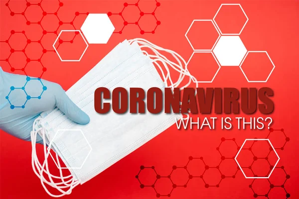 Cropped view of scientist holding medical masks near coronavirus what is this lettering on red — Stock Photo