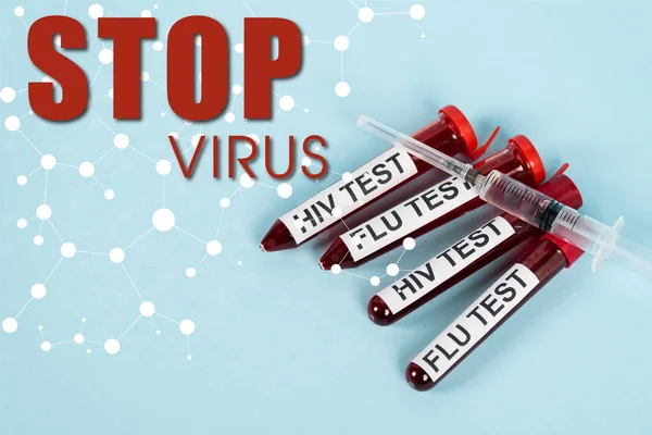 Top view of syringe on samples with hiv test and flu test near top virus lettering on blue — Stock Photo