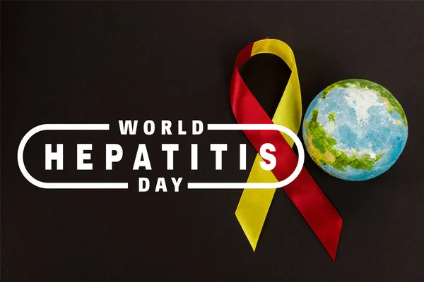 Globe and ribbon near world hepatitis day lettering on black — Stock Photo