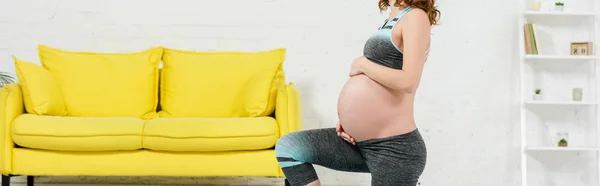 Vista ritagliata della ragazza incinta che si esercita in soggiorno, colpo panoramico — Foto stock