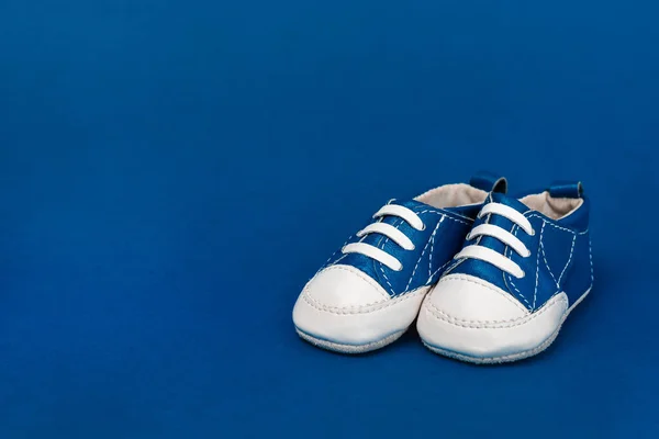 Baby shoes on blue background with copy space — Stock Photo
