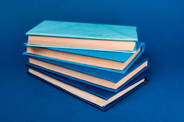 Яркие книги с копировальным пространством на синем фоне — стоковое фото