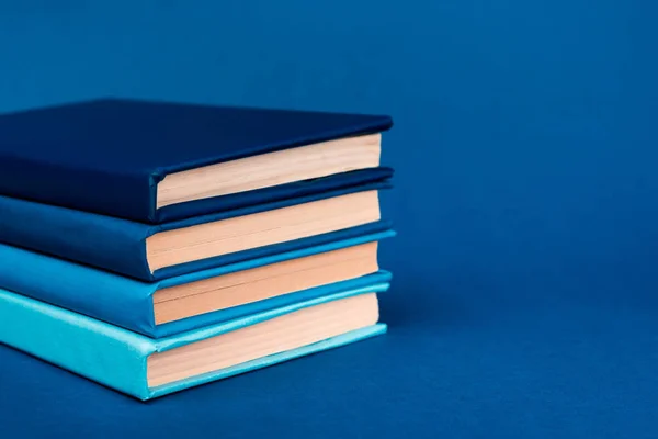 Livros brilhantes sobre fundo azul com espaço de cópia — Fotografia de Stock