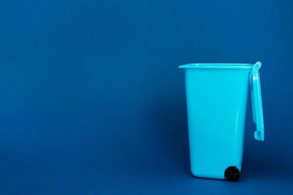 Игрушечный мусорный бак на синем фоне с копировальным местом — стоковое фото