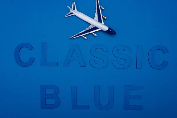 Cropped view model of plane and classic blue lettering on blue background — Stock Photo