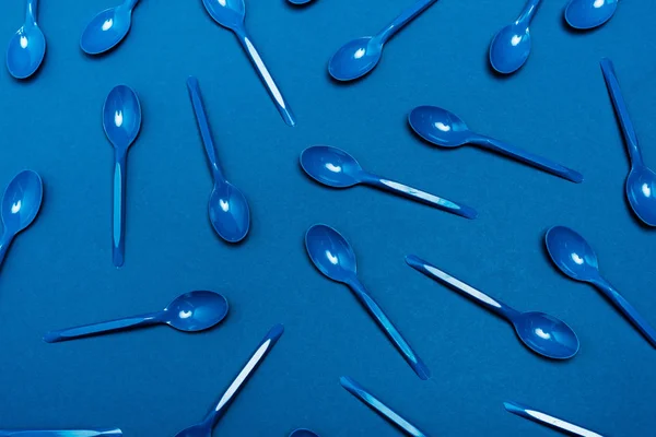 Top view of plastic spoons on blue background — Stock Photo