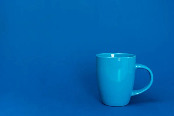 Cup of coffee on blue background with copy space — Stock Photo