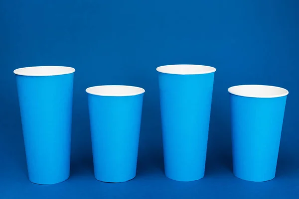 Coloridas tazas de papel con soda sobre fondo azul - foto de stock