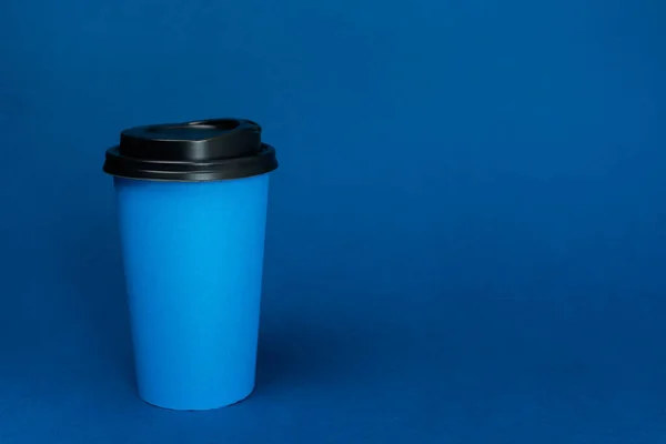 Паперові стаканчики з кавою на класичному синьому фоні з місцем для тексту — стокове фото