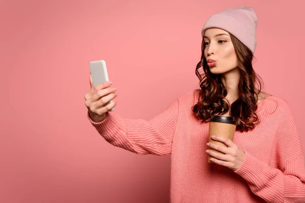 Attrayant fille avec canard visage expression prendre selfie tout en tenant cofee pour aller sur fond rose — Photo de stock