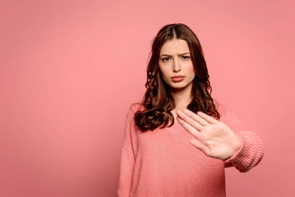 Disgustado chica mostrando stop gesto mientras mira a la cámara aislada en rosa - foto de stock