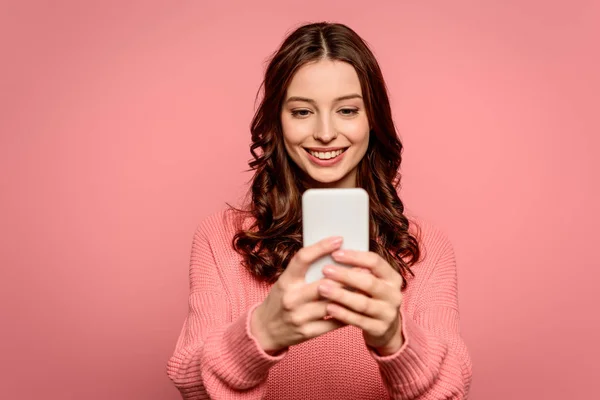 Happy girl smiling while having video chat on smartphone isolated on pink — Stock Photo