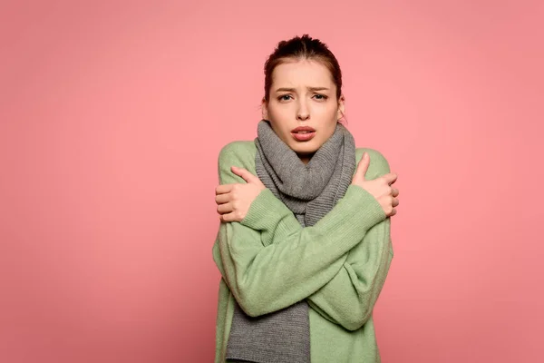 Diseased girl in warm scarf hugging herself while having fever isolated on pink — Stock Photo