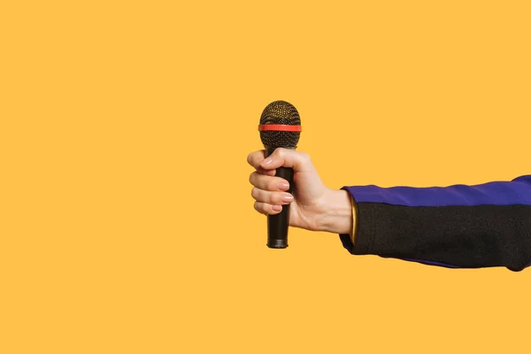 Ausgeschnittene Ansicht eines Reporters, der sein Mikrofon isoliert auf gelb hält — Stockfoto