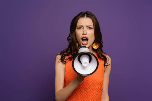 Menina animado gritando em megafone enquanto olha para a câmera isolada em roxo — Fotografia de Stock