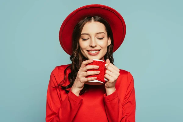 Menina elegante feliz desfrutando de sabor de café com olhos fechados isolados em azul — Fotografia de Stock