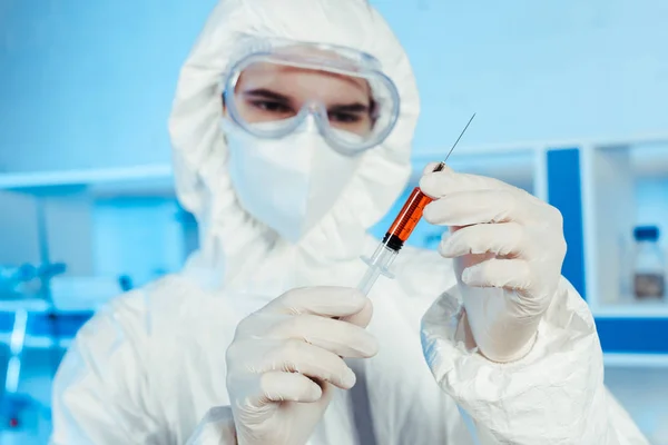 Selective focus of scientist in latex gloves holding syringe with vaccine — Stock Photo