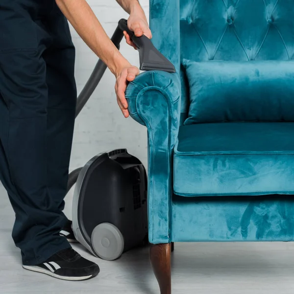 Vue recadrée de nettoyage à sec fauteuil bleu avec aspirateur — Photo de stock