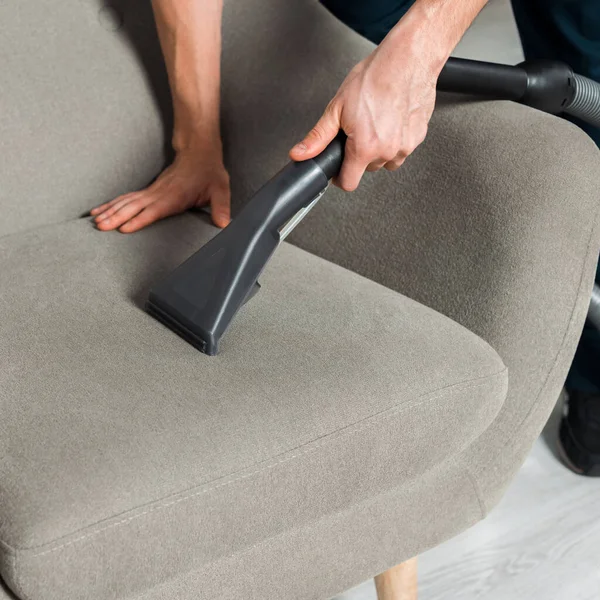 Cropped view of cleaner washing armchair with vacuum in living room — Stock Photo