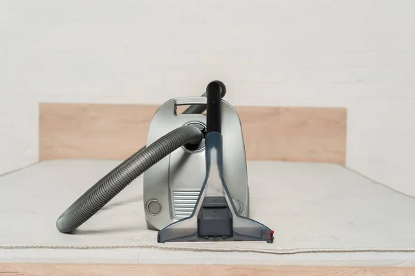 Aspirateur moderne avec poignée sur matelas dans la chambre — Photo de stock