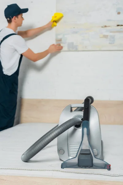 Selektiver Staubsaugerfokus in der Nähe eines jungen Mannes in Uniform — Stockfoto