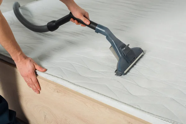 Cropped view of cleaner removing dust on mattress with vacuum cleaner — Stock Photo