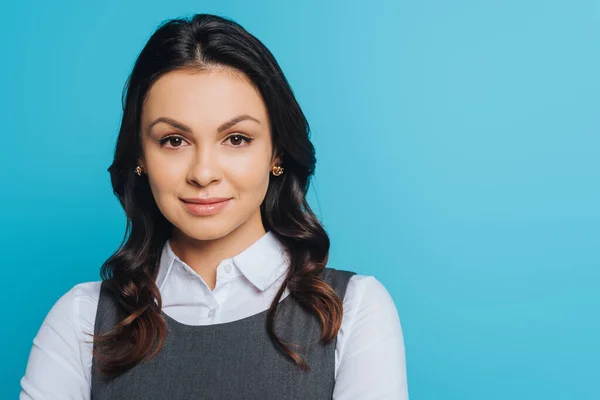 Attractive, confident businesswoman looking at camera isolated on blue — Stock Photo