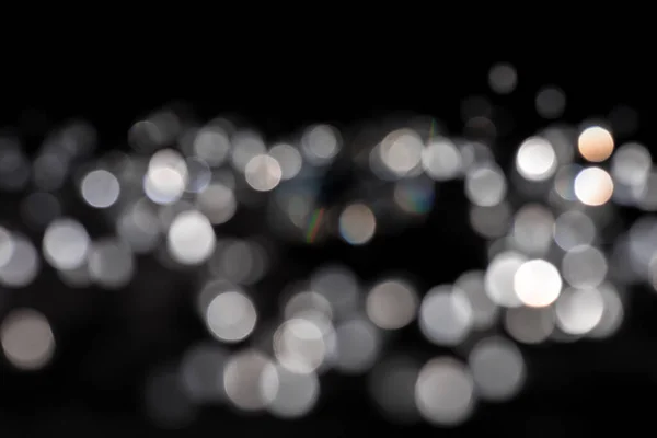 Background of white bokeh on black background — Stock Photo