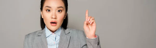 Excited young businesswoman in suit showing idea gesture isolated on grey background, panoramic shot — Stock Photo