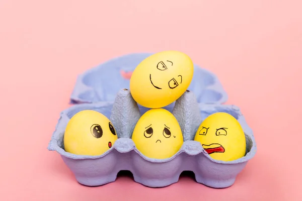 Selective focus of easter eggs with facial expressions in egg tray on pink — Stock Photo