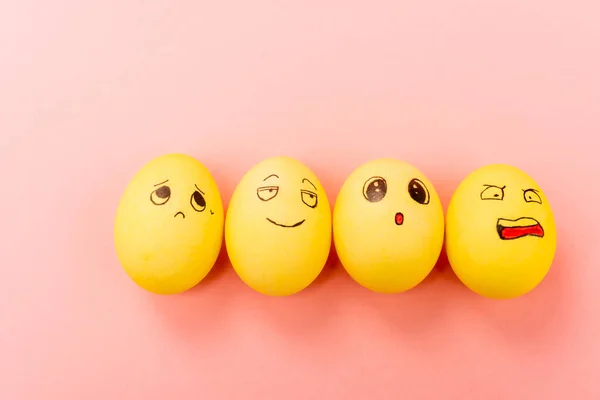 Visão superior de ovos de Páscoa com diferentes expressões faciais engraçadas no fundo rosa — Fotografia de Stock