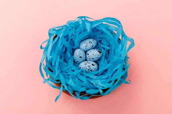 Vista de alto ângulo de ovos de codorna em ninho azul no fundo rosa, conceito de Páscoa — Fotografia de Stock