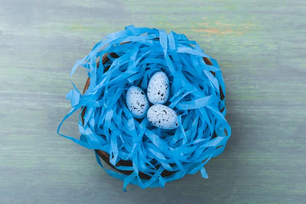 Ansicht des Nestes mit bemaltem Wachtelei auf hölzernem Hintergrund, Osterkonzept — Stockfoto