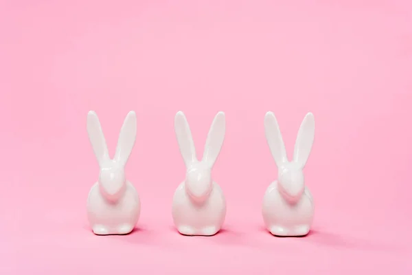 Lapins de Pâques décoratifs sur fond rose — Photo de stock