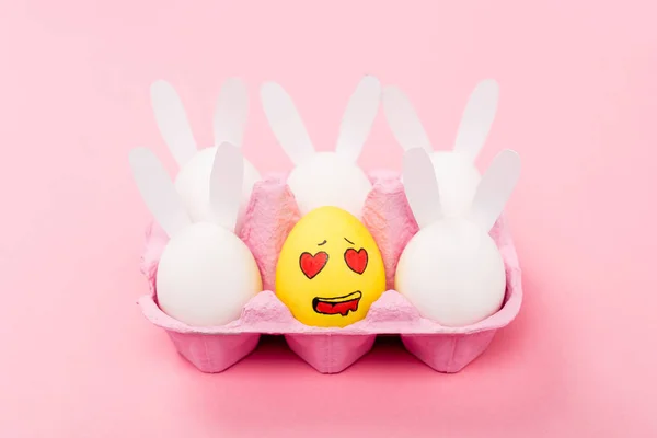 Conigli decorativi e uovo giallo con espressione facciale innamorata su rosa, concetto pasquale — Foto stock