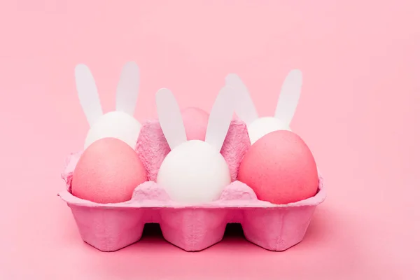 Decorative rabbits and easter eggs on pink background — Stock Photo