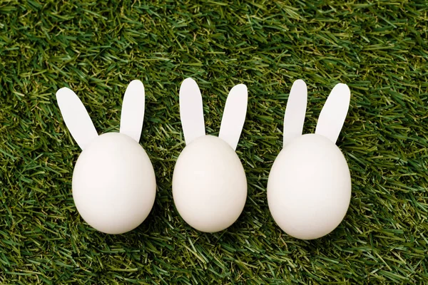 Vista dall'alto di coniglietti decorativi su sfondo verde, concetto di Pasqua — Stock Photo
