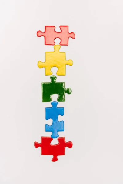 Top view of bright colorful pieces of puzzle isolated on white, autism concept — Stock Photo