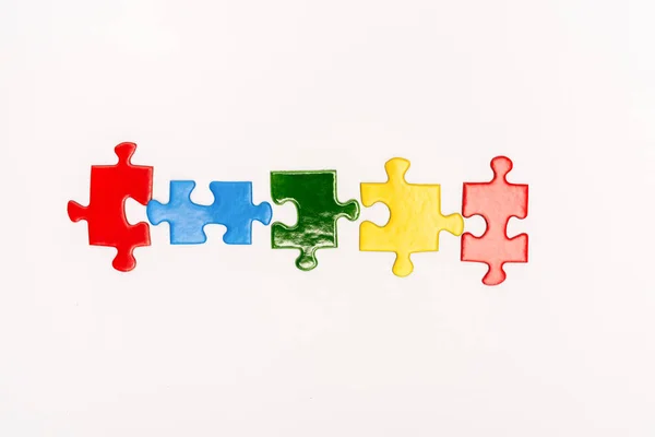 Top view of bright pieces of puzzle isolated on white, autism concept — Stock Photo