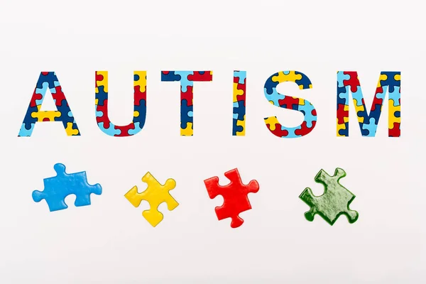 Vista dall'alto di Autismo puzzle lettering su bianco — Foto stock
