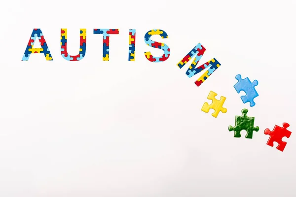 Vista superior da inscrição do quebra-cabeça do autismo no fundo branco — Fotografia de Stock